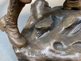a bronze statue of a man holding a bird on a rock