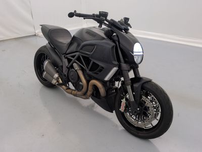 une moto noire garée dans une pièce aux murs blancs