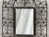 Miroir mural en fer forgé au motif ouvragé, avec cadre en verre