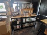 a room with a table, shelves, chairs, and a refrigerator