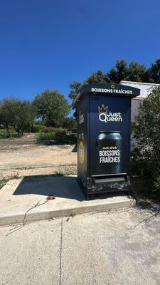 a trash can sitting on the side of the road