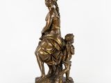a bronze statue of a woman sitting on a rock with a child