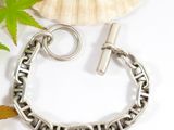 a close up of a silver chain bracelet with a clasp