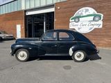 a black car parked in front of a building with a sign that says classic car company