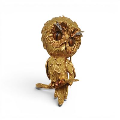 une image représentant une figurine en or en forme de chouette perchée sur une branche d'arbre