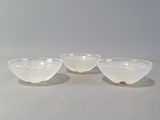 trois bols en verre blanc posés sur une table blanche
