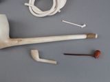 a pipe, a pipe holder, a pipe holder, and a pair of scissors on a table