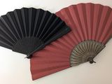 deux éventails noirs et rouges sur fond blanc