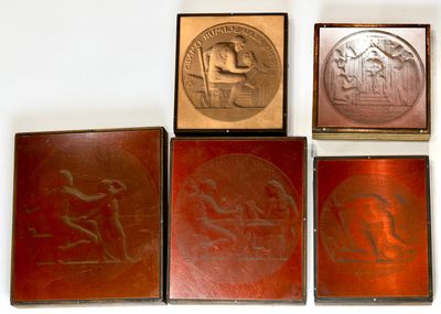 four different types of metal plaques on display on a white surface