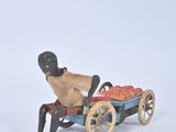 figurine of a man sitting on a bench with a cart of fruit