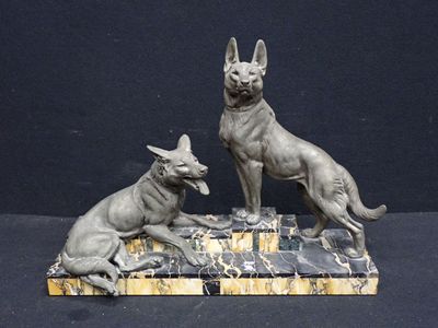 statue of two dogs sitting on a marble base on a black background