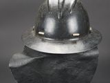 a helmet sitting on top of a rock on a black surface
