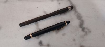 deux stylos posés sur une table en marbre