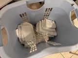 a white laundry basket with clothes inside of it