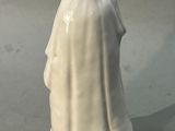 une figurine blanche représentant une femme tenant un oiseau
