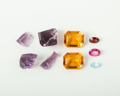 several different colored gems on a white surface with a white background