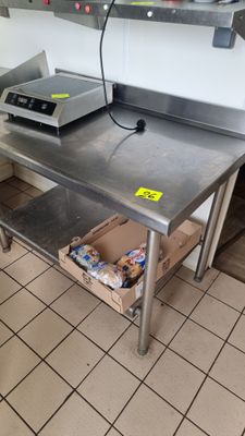 une table en métal sur laquelle se trouve une boîte, dans une cuisine