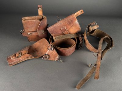 several pieces of leather are sitting on a gray surface