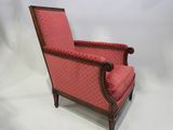 une image représentant une chaise dont le dossier et les accoudoirs sont recouverts de tissu rouge
