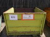 a green dumpster sitting in front of a metal fence