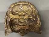 a bronze mask on display on a table