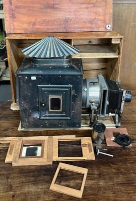 un vieil appareil photo posé sur une table à côté d'une boîte en bois