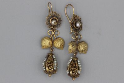une paire de boucles d'oreilles ornées de feuilles et de perles