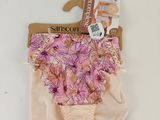 La culotte est rose et ornée de fleurs ; elle est suspendue à un cintre.