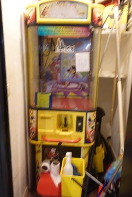 un chat allongé par terre à côté d'un distributeur automatique de jouets