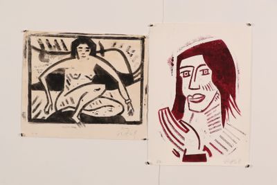 two paintings of a woman and a man are hanging on a wall