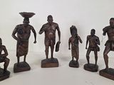 six bronze figurines of african men with bowls on their heads