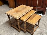 trois tables en bois posées sur un sol en béton, à côté d'une armoire