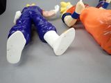 three figurines of people laying on a table