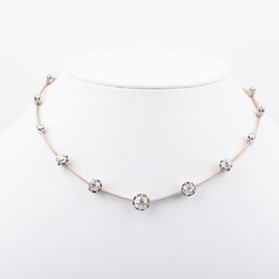 a white and silver necklace on a mannequin neck