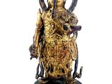 une statue en or représentant une femme tenant un serpent