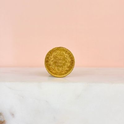 a gold coin sitting on top of a marble slab