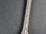 a silver spoon that is laying on a black surface