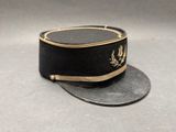 chapeau noir avec une bordure dorée sur fond gris