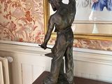 a statue of a man holding a knife on a table