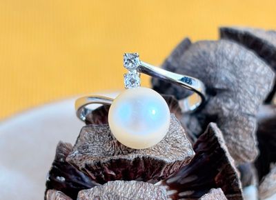 a white pearl ring sitting on top of a piece of chocolate