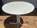 an image of a white table sitting on top of a brick patio