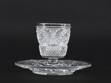 crystal cup and saucer on a plate on a black background