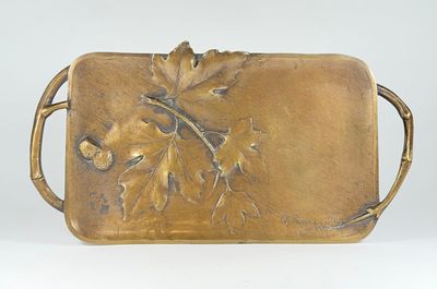 a metal tray with a leaf design on it