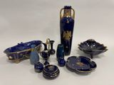 de nombreux objets de différentes formes, bleus et dorés, posés sur la table