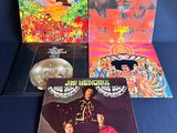 trois albums vinyles des Beatles, dont l'un comporte la photo d'un homme coiffé d'un chapeau et d'une femme en robe rouge