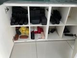 a white cabinet with a bunch of luggage on it