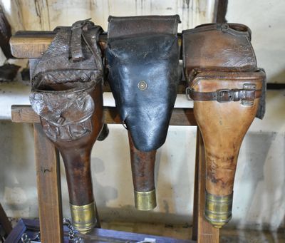 three pairs of leather baseball bats hanging on a rack