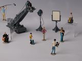 de nombreuses figurines représentant des personnes debout devant un appareil photo