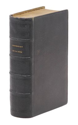 un vieux livre noir avec une reliure dorée sur fond blanc