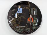 a black plate with a picture of a man and a woman on it